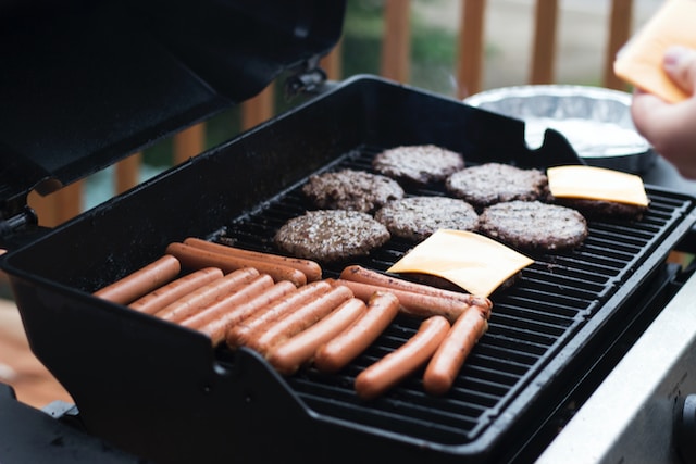 sosis, daging, dan lainnya sedang dimasak diatas griddle